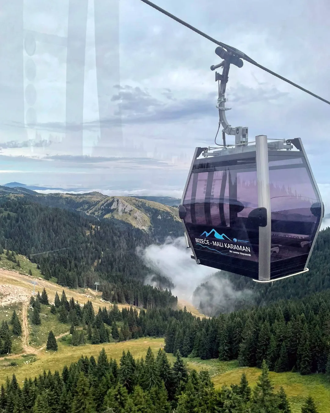 Cabină a telegondolei vara, deasupra pădurilor și pajiștilor de pe Kopaonik